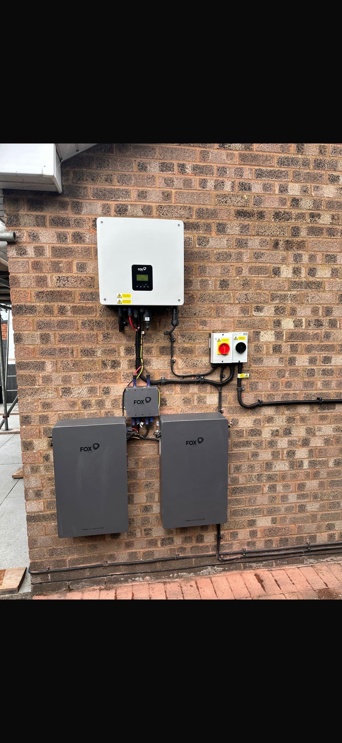 Wall-mounted home battery storage installed on a brick exterior